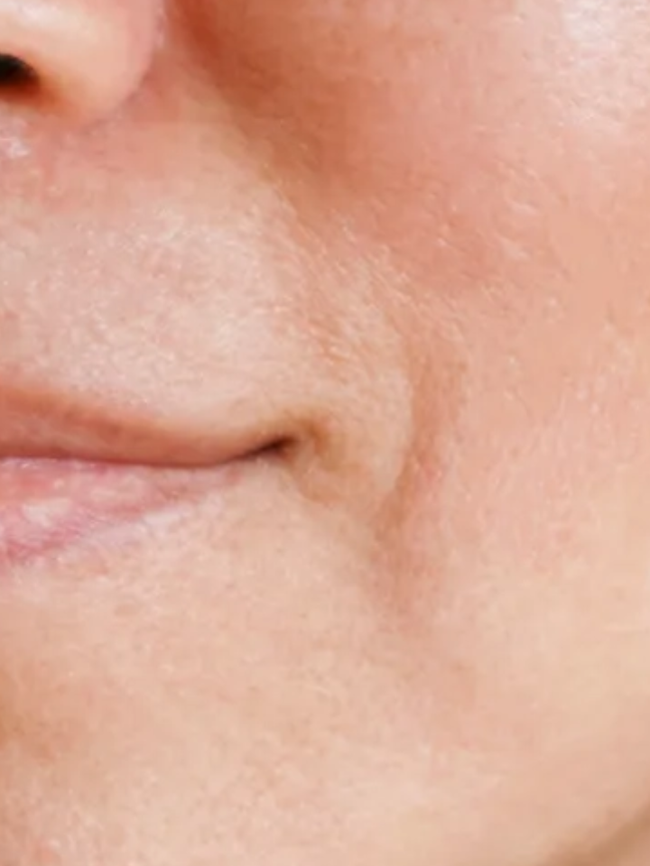 Close-up of a person's mouth and chin area with visible skin texture.