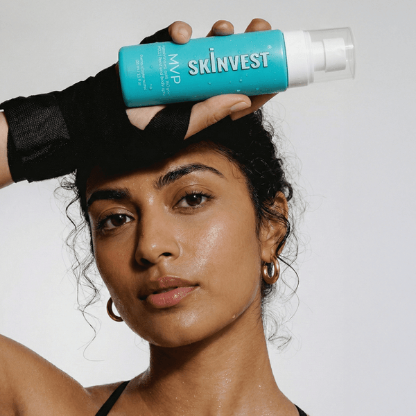 Woman holding a Skinvest product against a white background