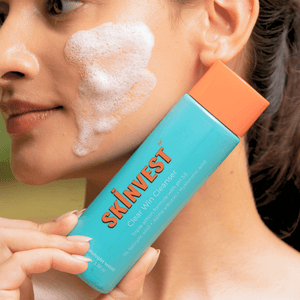 Person applying SKINVEST cleanser to their face with a close-up of the product.