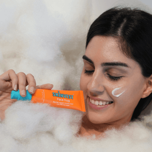 Woman holding a skincare product with bubbles in the background