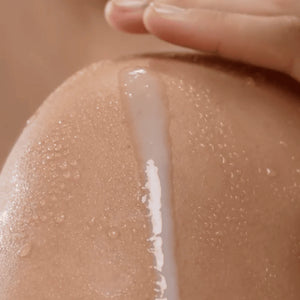 Close-up of a hand applying a white cream or lotion to skin
