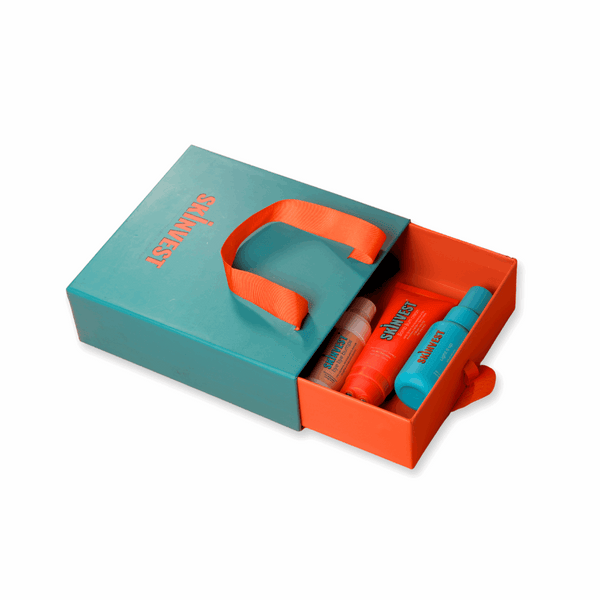 Skincare product set with teal box and orange accents on a white background