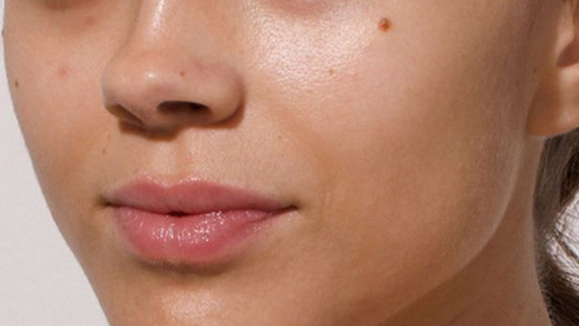 Close-up of a person's face with visible skin texture and lip color.