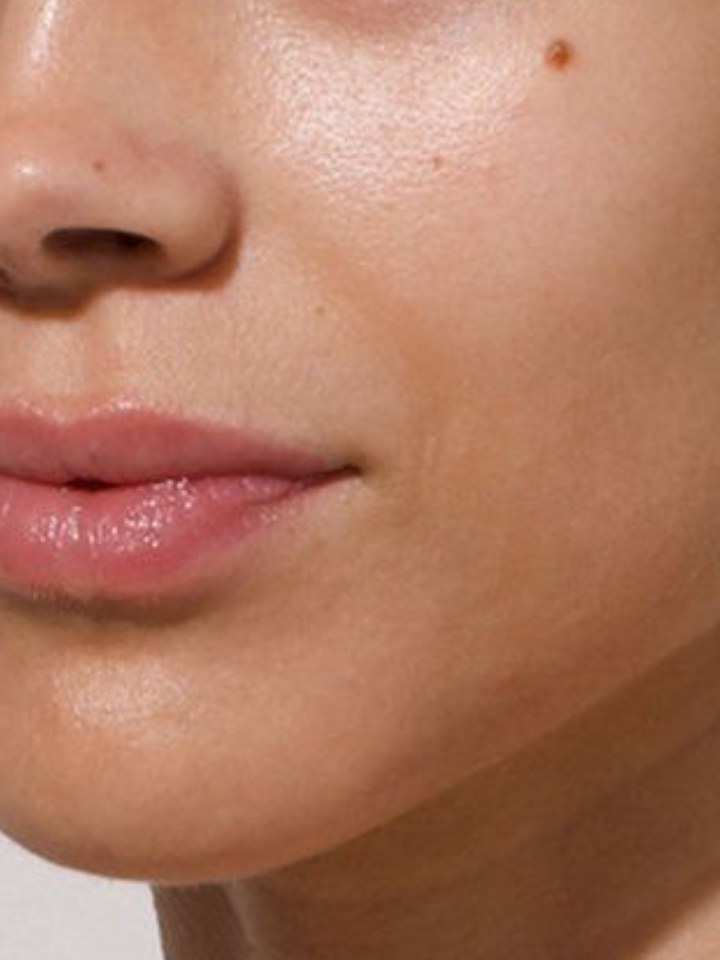 Close-up of a person's lips and chin with a neutral background